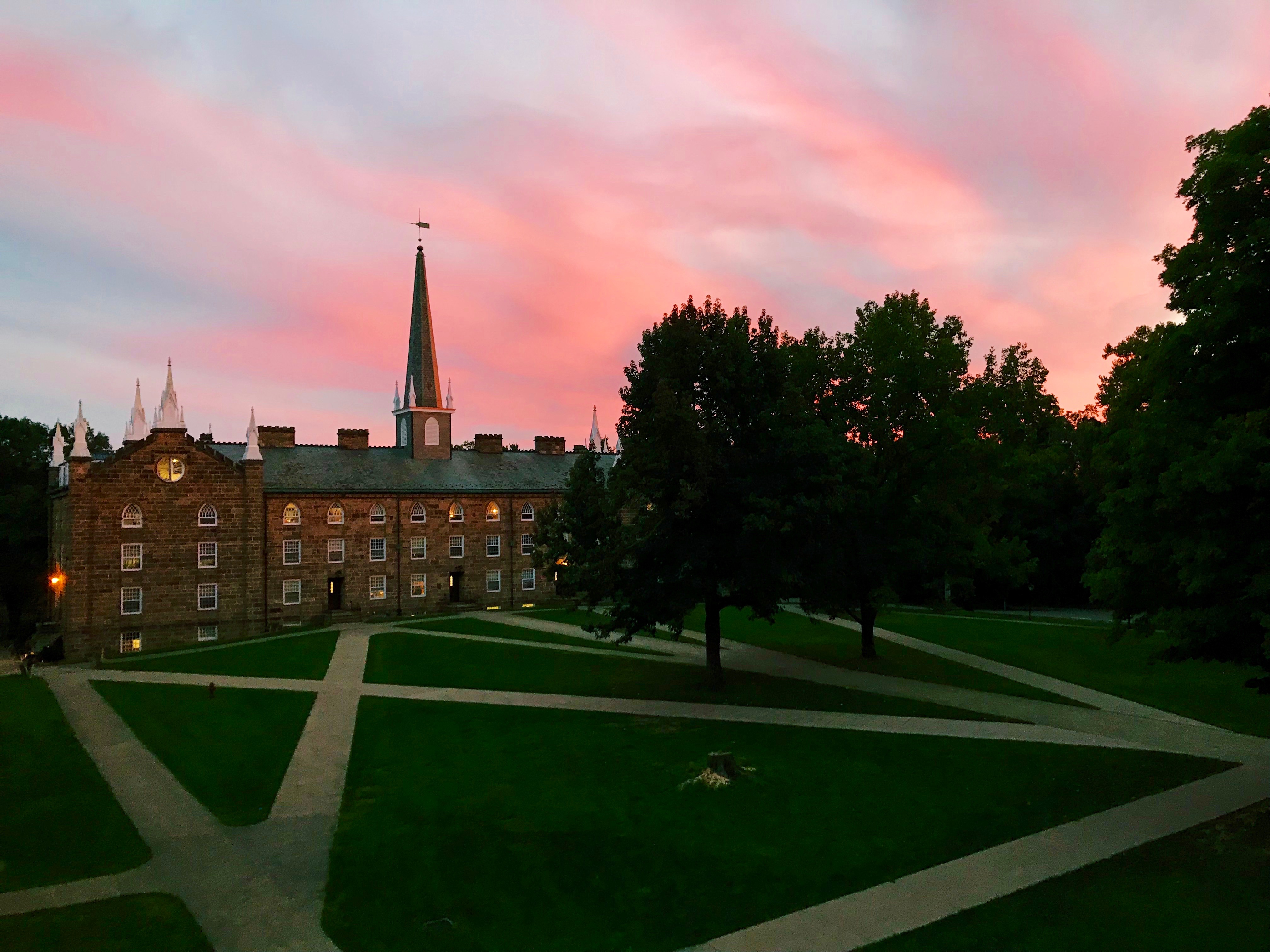 A photo of Old Kenyon at sunset with a pink sky.
